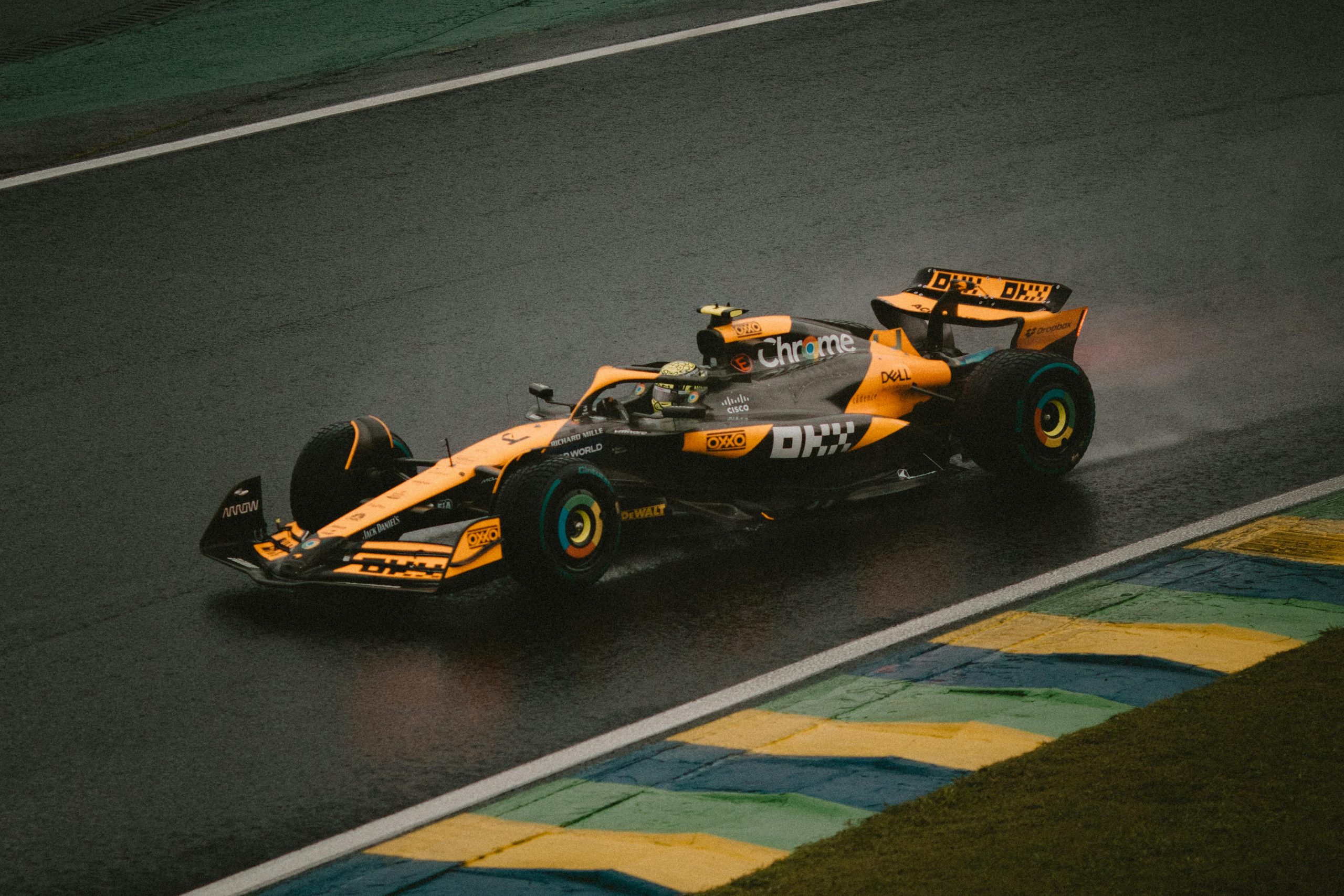 yellow and black Formula race car speeding down a track